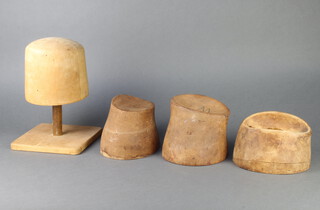 A 1930's oval wooden hat block marked 678V 0685 10cm x 19cm x 16cm (pin marks) and 3 others 13cm x 19cm x 15cm marked B0889, 14cm x 17cm diam. N44 and 15cm x 16cm x 19cm with an associated wooden base