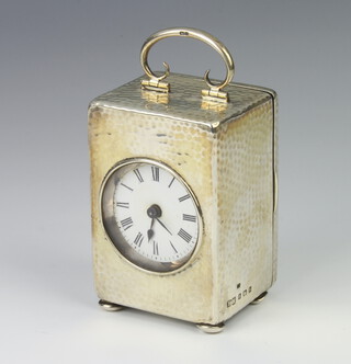 An Edwardian silver hammered pattern table timepiece on bun feet Birmingham 1907, 11cm 