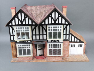 A 1930's dolls house in the form of a mock Tudor house 56cm h x 81cm w x 33cm d 
 