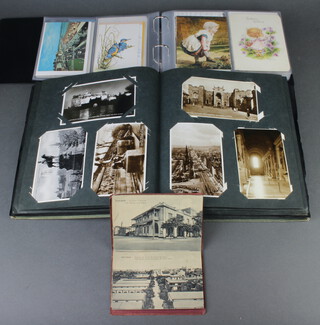 A small album of postcards of Port-Said, a green album of black and white and coloured postcards, a red ring bound album of coloured postcards