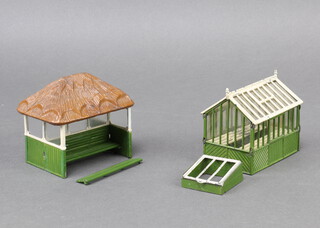 A 1930's Britains miniature garden greenhouse 053 complete with staging together with a garden shelter 28MG with seat and a cold frame 