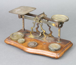 A pair of brass postage scales raised on a shaped mahogany base complete with weights 12cm h x 25cm w x 13cm d 