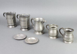Two Victorian pewter pint tankards the bases indistinctly engraved Naylor, a pewter spouted jug raised on a circular foot 12cm x 9cm, 2 Victorian pewter half pint measures, 2 small pewter dishes 10cm 