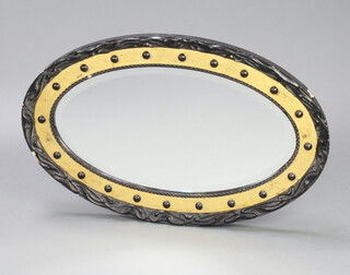 A Victorian oval bevelled plate wall mirror contained in an ebonised and gilt ball studded frame 74cm x 46cm x 3cm 