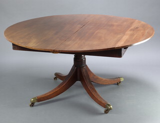 A circular Georgian mahogany pedestal extending dining table raised on turned column and tripod supports, brass caps and casters 70cm h x 146cm w x 144cm when closed x 242cm when extended 