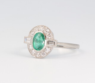 A white metal stamped Plat. Art Deco style emerald and diamond ring, the centre stone 0.95ct, the surrounding diamonds 0.3ct, 3.6 grams, size O 
