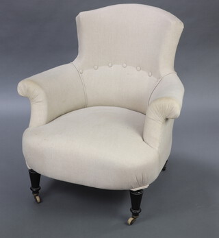 A Victorian armchair upholstered in white buttoned material, raised on ebonised turned supports, brass caps and casters 82cm h x 78cm w x 60cm d 