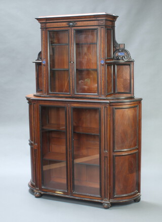 A 19th Century Continental walnut bow front display cabinet on cabinet, the upper section fitted a cupboard enclosed by panelled doors and having lapis lazuli panels, the bow front base fitted shelves enclosed by panelled doors, raised on bun feet 187cm h x 128cm w x 36cm d 