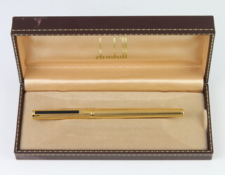 A gentleman's Dunhill gold plated engine turned fountain pen with 14ct nib in original box 