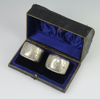 A pair of Edwardian silver napkin rings with floral decoration, cased, Sheffield 1901, 60gms