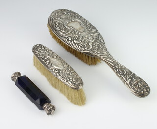 A white metal mounted double ended blue glass scent together with repousse hair brush and clothes brush 