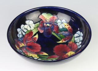 A William Moorcroft fruit bowl, the blue ground decorated with flowers, Queen Mary label monogram and impressed mark 22cm