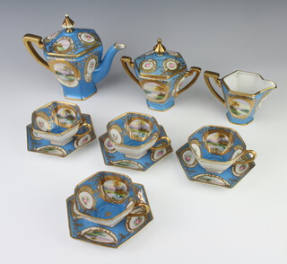 A Noritake blue ground tea set decorated with panels of flowers and landscapes comprising teapot, lidded sugar bowl, cream jug, 4 tea cups and 4 hexagonal saucers 