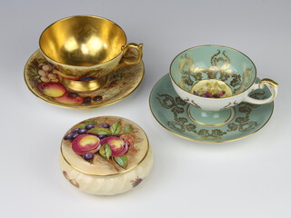 An Aynsley tea cup and saucer decorated with fruits by D Jones, a ditto box and cover and cabinet cup and saucer 