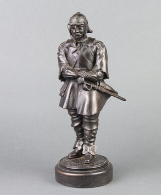 A bronzed figure of a standing cavalier raised on a circular base marked Elton CD 1990, 27cm h x 9cm