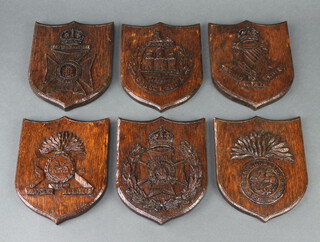 Six carved oak shield shaped regimental wall plaques - The Lancashire Fusiliers, Dorset Regt., London Irish Rifles, Northumberland Fusiliers, 16th County of London Rifles and The 19th Battalion London Regt. 18cm x 15cm  

