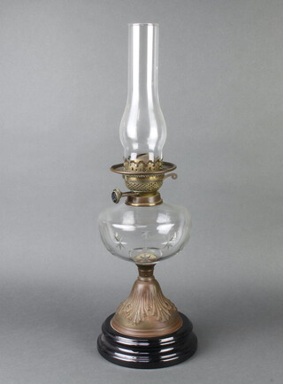 A Victorian cut glass oil lamp reservoir raised on an embossed metal base with ceramic socle base, complete with glass chimney 58cm h x 16cm 