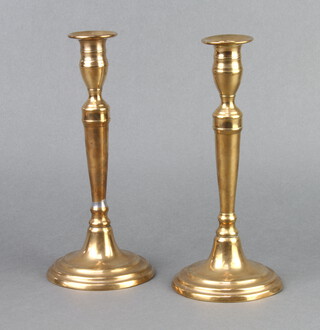 A pair of 18th/19th Century brass candlesticks with ejectors raised on circular bases 24cm x 10cm 