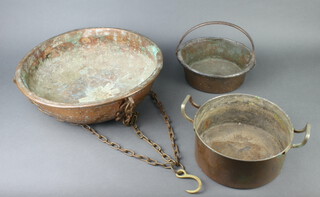 A copper cylindrical preserving pan with iron handles 8cm x 23cm, a copper twin handled pot 10cm x 22cm and a circular copper and brass hanging pot 11cm x 40cm 