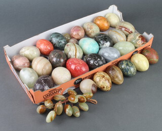 Thirty one various carved hardstone eggs together with a bunch of hardstone grapes 