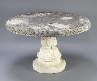 A circular well weathered concrete garden table raised on a pedestal support 74cm h x 125cm diam. 