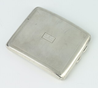 A silver engine turned cigarette case with engraved monogram, Birmingham 1930, 134 gms, 10.5cm 