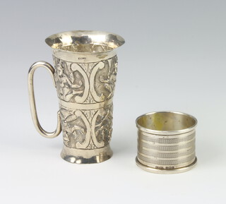 An Indian white metal repousse tapered cup with deities 8cm together with a silver napkin ring, rubbed marks, 96gms  
