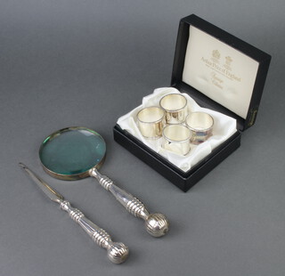 A cased set of 4 silver plated napkin rings, a magnifying glass and paper knife 