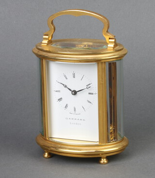 Garrard, a 20th Century 8 day carriage timepiece with enamelled dial and Roman numerals contained in an oval gilt metal case 12cm x 10cm x 7cm, complete with key 