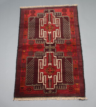 A red, blue and white ground Belouche rug with 2 medallions to the centre 133cm x 84cm 