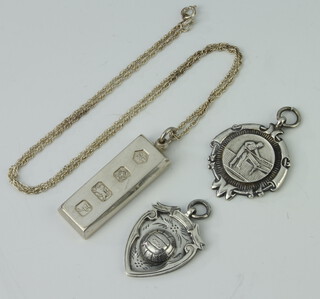 A silver ingot and chain, a silver sports fob, 42gms, a plated ditto 