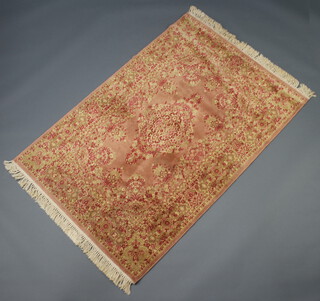 A pink and gold ground machine made Persian style rug with central medallion 180cm x 120cm