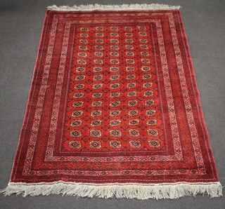 A red and white ground Afghan carpet with multi row border and 75 octagons to the centre 278cm x 195cm 