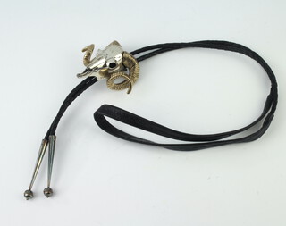 A white metal and gilt rams skull necktie pendant on a leather strap 