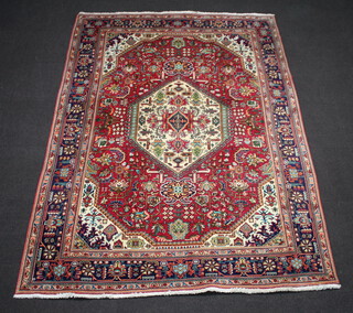 A red and blue ground Persian carpet with central medallion within a multi row border 297cm x 201cm 