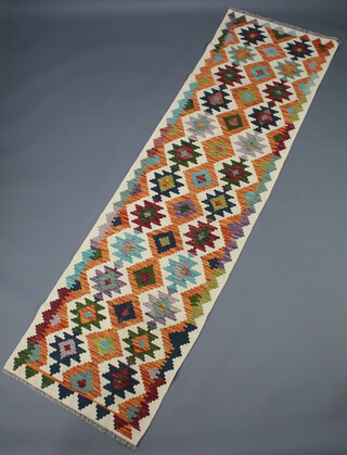 A white, brown, tan and black ground Chobi Kilim runner with all over geometric designs 295cm x 82cm 