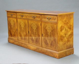 A Georgian style walnut oyster veneer and crossbanded sideboard, fitted a drawer above double cupboard, flanked by 2 drawers above cupboard enclosed by panelled doors 82cm h x 180cm w x 45cm d 