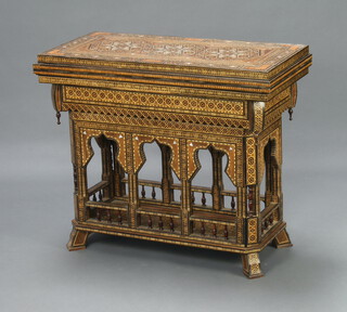 A Moorish inlaid games table with arched and bobbin turned decoration to the apron, the interior fitted a backgammon board, a card table and chess board, raised on outswept supports 79cm h x 92cm w x 46cm  