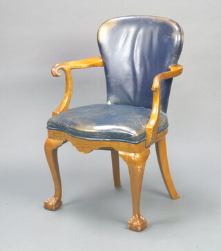 A 1930's carved walnut open armchair with carved eagle arm rests, the seat and back upholstered in blue leather, raised on cabriole, ball and claw supports 91cm h x 63cm w x 44cm d (seat 35cm x 33cm) 