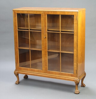 A Queen Anne style figured walnut display cabinet fitted adjustable shelves enclosed by astragal glazed panelled doors, raised on cabriole paw supports 123cm h x 107cm w x 34cm d 