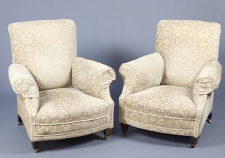 A pair of Edwardian armchairs upholstered in gold material raised on square tapered supports ending in brass casters 89cm h x 84cm w x 70cm d (seat 31cm x 41cm) 