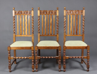 A set of 3 1930's carved light oak stick and bar back dining chairs with spiral turned decoration and upholstered seats, raised on turned and block supports 109cm h x 45cm w x 41cm d 