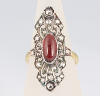 A yellow metal Edwardian style cabochon garnet and diamond cocktail ring, the centre stone 0.7ct, size N, 3.9 grams 