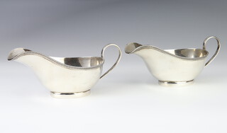 A pair of silver Art Deco sauce boats with scroll handles, Sheffield 1932, 296 grams