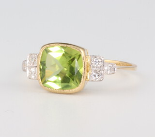 A yellow metal 18ct peridot and diamond ring, the centre stone approx. 2.1ct, the 6 brilliant cut diamonds 0.20ct, size N 1/2. 3 grams