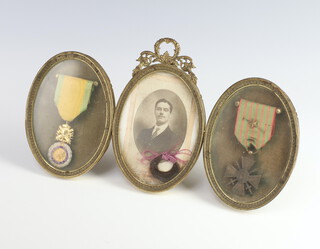 A French Military Medal and a Croix de Guerre framed together with a portrait of a gentleman with a lock of hair in a gilt metal mounted 3 section frame  
