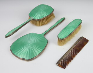 A silver and green guilloche enamel dressing table set comprising hand mirror, clothes brush, hair brush (a/f) and a silver mounted comb 