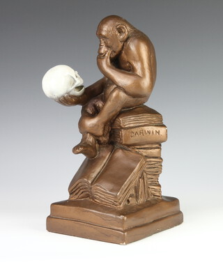 After Hugo Rheinhold, a mid-Century plaster figure of a chimpanzee holding a skull, sitting on a pile of books, 1 marked Darwin by Austin Prod. Inc. 1969 33cm 