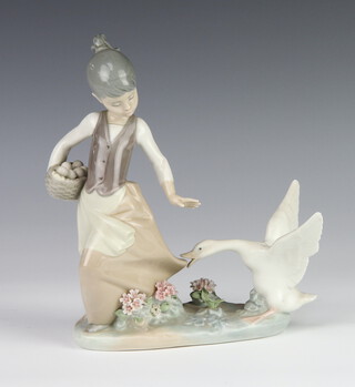 A Lladro figure of a girl holding a basket of eggs with a goose at her feet 19cm 