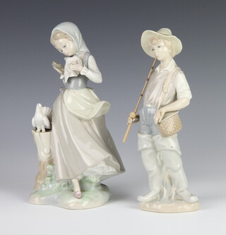 A Lladro figure of a boy fisherman 22cm, a ditto of a girl holding a dove 21cm 